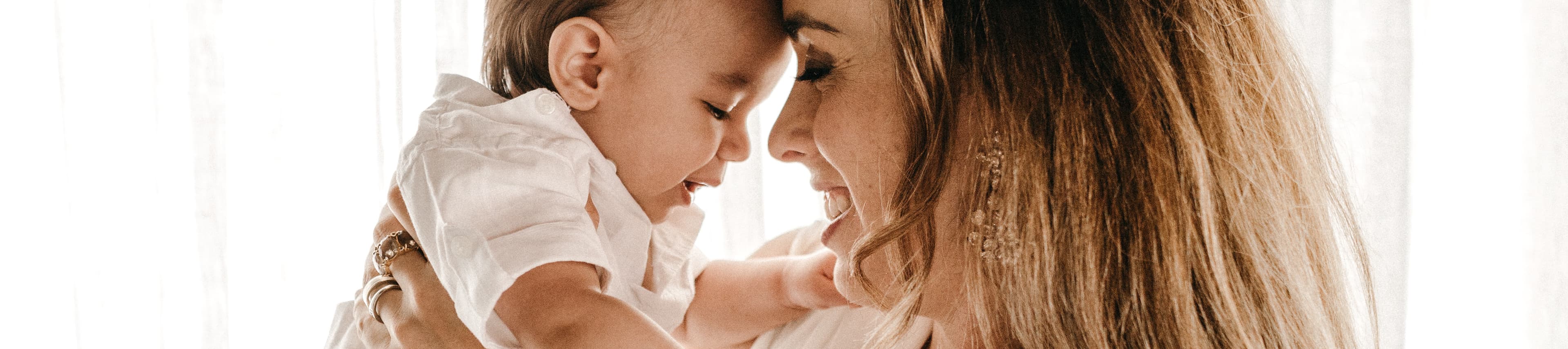 A mother snuggling her baby. Photo credit to Jonathan Borba on Unsplash.